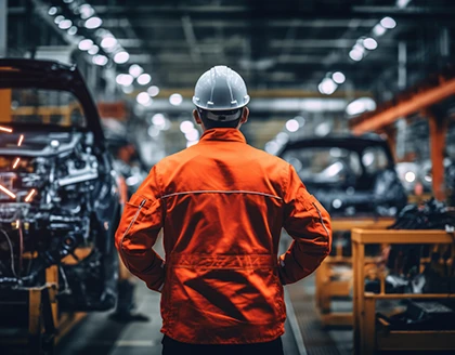 Worker in the background car manufacturing plant.