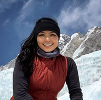 Amitha sitting in front of snowy mountains.