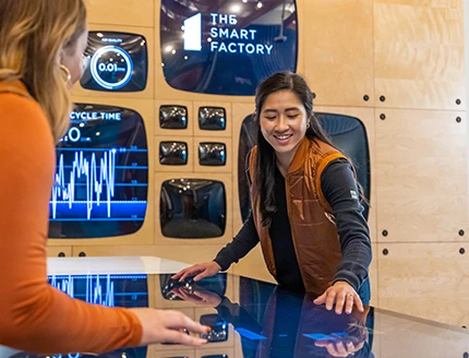 Two women smiling in The Smart Factory Welcome Room.