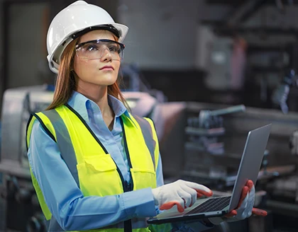 Asian factory worker woman holding laptop.