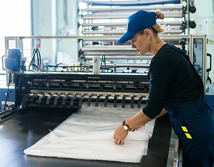 Woman worker in the production of plastic packaging folds finished products.