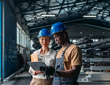 Two factory workers looking at tablet.