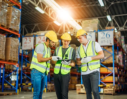 3 warehouse workers using digital tablet.