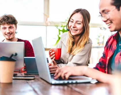 Young people using laptops in startup studio.