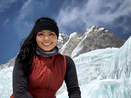 Amitha sitting in front of snowy mountains.